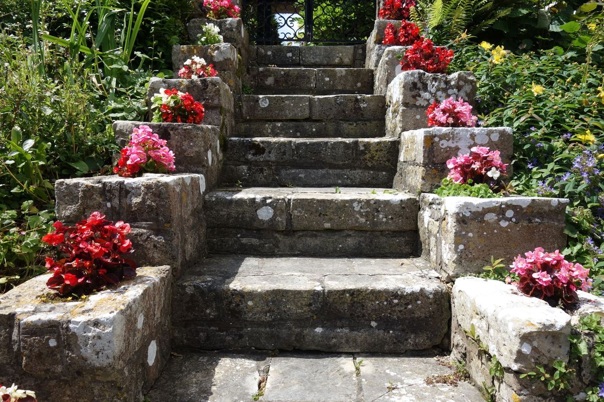 Rustic stone garden steps lined with flowering planters
